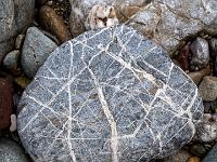 Dichte weiße Kreuzmaserung in grauem Stein